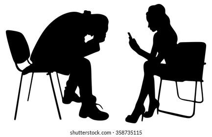 Depressed man sitting with his girlfriend texting on her cell phone