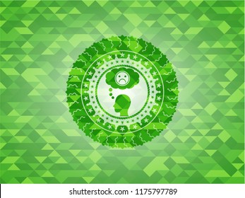 depression icon inside green emblem with triangle mosaic background