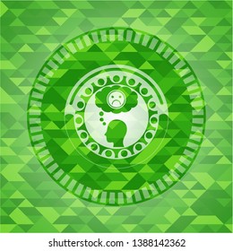 depression icon inside green emblem with triangle mosaic background