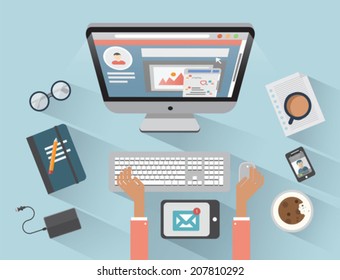 Desk with computer and various media devices on blue background