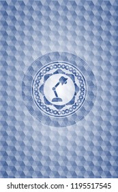 desk lamp icon inside blue badge with geometric pattern.