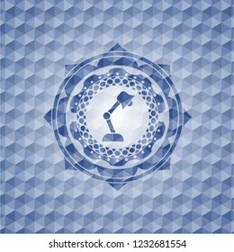 desk lamp icon inside blue emblem or badge with abstract geometric polygonal pattern background.