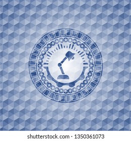 desk lamp icon inside blue emblem or badge with geometric pattern background.