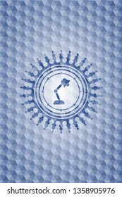desk lamp icon inside blue emblem with geometric pattern background.