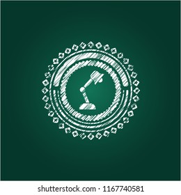 desk lamp icon inside chalkboard emblem written on a blackboard