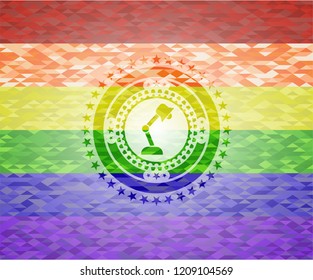 desk lamp icon inside emblem on mosaic background with the colors of the LGBT flag