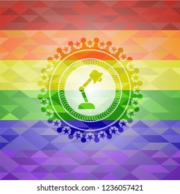 desk lamp icon inside emblem on mosaic background with the colors of the LGBT flag