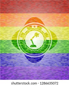 desk lamp icon inside emblem on mosaic background with the colors of the LGBT flag