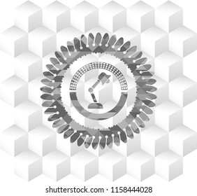 desk lamp icon inside grey emblem with cube white background