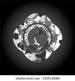 desk lamp icon inside grey camouflaged emblem