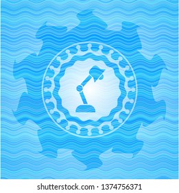 desk lamp icon inside light blue water wave style emblem.