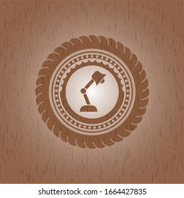 icono de la lámpara de escritorio dentro de un emblema de madera realista