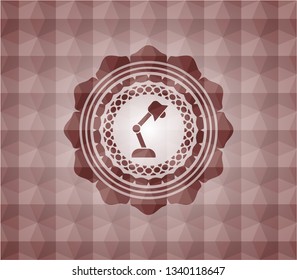 desk lamp icon inside red seamless emblem or badge with abstract geometric polygonal pattern background.