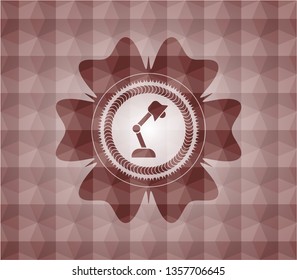 desk lamp icon inside red seamless badge with geometric pattern.