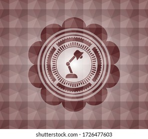 desk lamp icon inside red seamless badge with geometric pattern. 