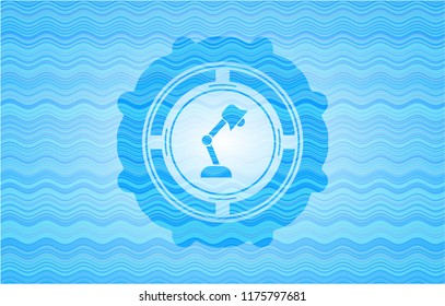 desk lamp icon inside sky blue water emblem.