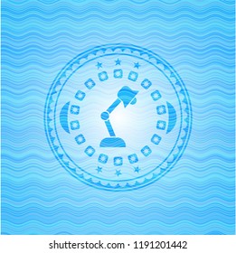 desk lamp icon inside sky blue water badge background.