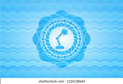 desk lamp icon inside sky blue water badge.