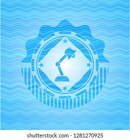 desk lamp icon inside sky blue water emblem.