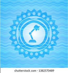 desk lamp icon inside sky blue water wave style badge.