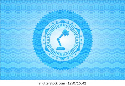 desk lamp icon inside water wave badge.