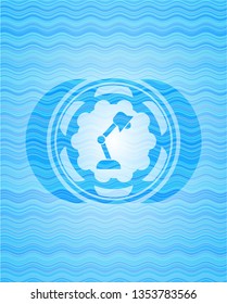 desk lamp icon inside water style emblem.