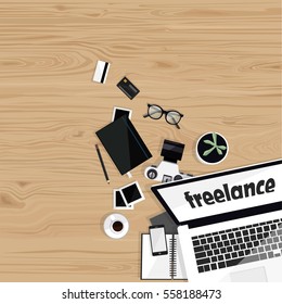 Desktop with laptop, camera, mobile, notebooks, glasses, credit cards, photos and cup of coffee on wood background. Top view. Office table. Freelance background.