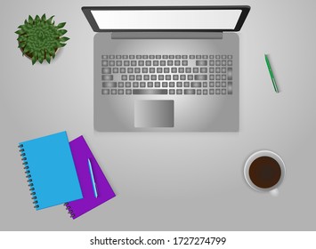 Desktop with laptop and notebooks, coffee and a flower in a pot