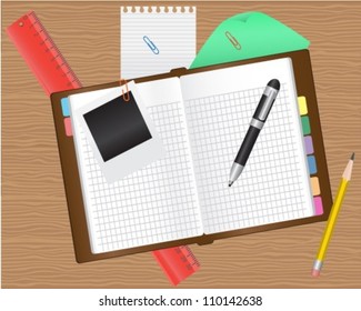 diary and office supplies on a wooden table