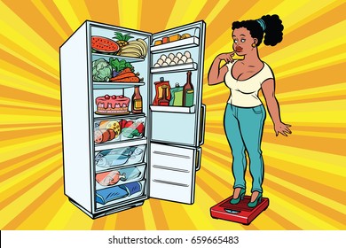 Diet. Young woman on scales, stand next to the refrigerator with