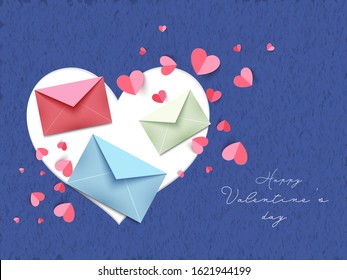 Diferentes sobres de color con corazones de papel decorados con fondo de textura de hormigón azul para el feliz día de San Valentín.