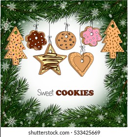 Different kinds of home made cookies hanging on threads. Decorative frame with fir branches and snowflakes.