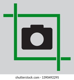 Digital camera sign. Black icon inside green crop tool at light gray background