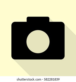 Digital camera sign. Black icon with flat style shadow path on cream background.