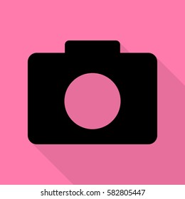 Digital camera sign. Black icon with flat style shadow path on pink background.
