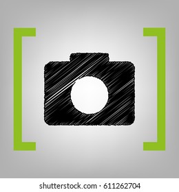 Digital camera sign. Vector. Black scribble icon in citron brackets on grayish background.