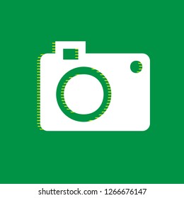 Digital camera sign. Vector. White flat icon with yellow striped shadow at green background.