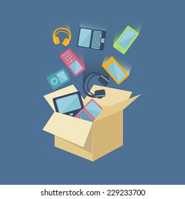 Digital devices as laptop, desktop computer, mobile phones, headset and portable music players falling into an open card board box