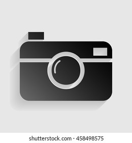 Digital photo camera sign. Black paper with shadow on gray background.