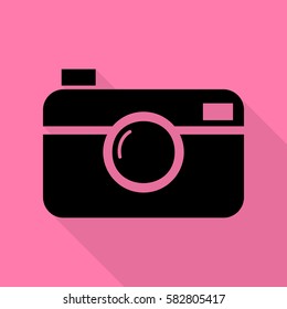 Digital photo camera sign. Black icon with flat style shadow path on pink background.