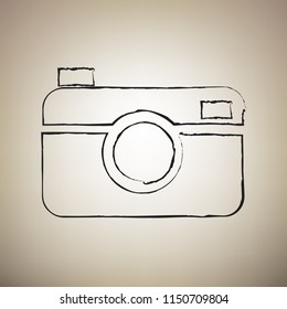 Digital photo camera sign. Vector. Brush drawed black icon at light brown background.