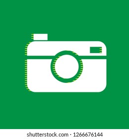 Digital photo camera sign. Vector. White flat icon with yellow striped shadow at green background.