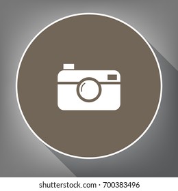 Digital photo camera sign. Vector. White icon on brown circle with white contour and long shadow at gray background. Like top view on postament.