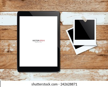 Digital tablet and blank photo frame on vintage wooden texture background. Vector illustration.
