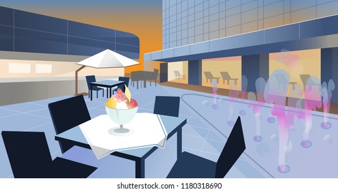 Dining table with ice-cold fruit in front of hotel outdoor fountain