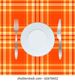 Dinner plate, knife and fork over orange tablecloth