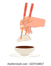 Dip gyoza in soy sauce. Chinese chopsticks in hand.