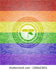 directions sign icon inside emblem on mosaic background with the colors of the LGBT flag