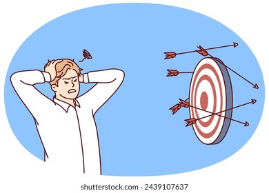 Discouraged man clutching head standing near darts board after failed attempts to hit target. Concept problems in business due to inability to complete task or KPI. Flat vector illustration