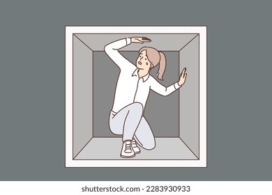 Discouraged woman is trapped sitting in small box experiencing claustrophobia and repressed emotions. Claustrophobic girl for business concept hopeless situation causing stress and lack of motivation 